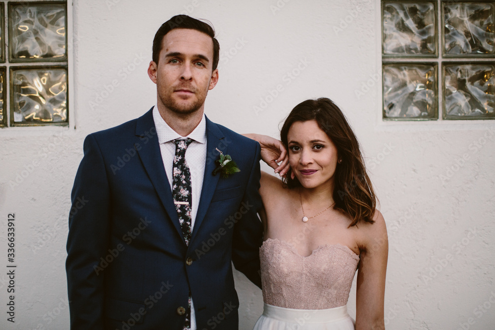 bride and groom against wall outside on wedding day. bride and groom against wall outside on wedding day.