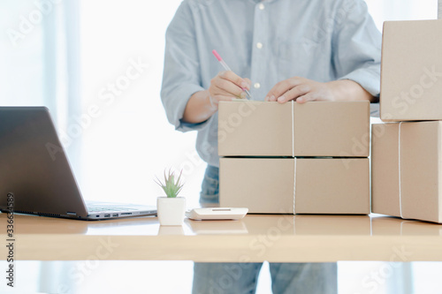 Online shopping young start small business in a cardboard box at work. The seller prepares the delivery box for the customer, online sales, or e commerce.