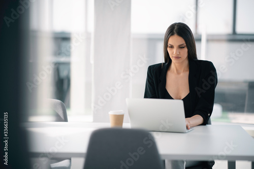Beautiful businesswoman working on lap top. Young happy woman in office.