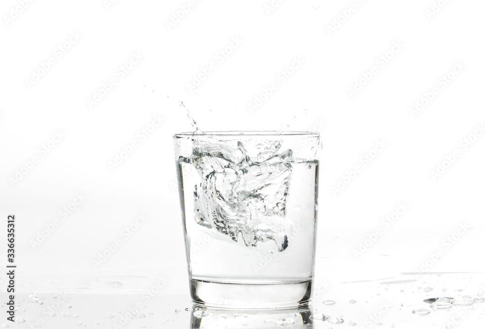 Glass with water and ice on a white background. Glass of mineral water and ice on white background.