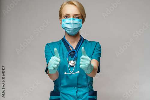 medical doctor nurse woman wearing protective mask and latex gloves - showing big thumb up photo