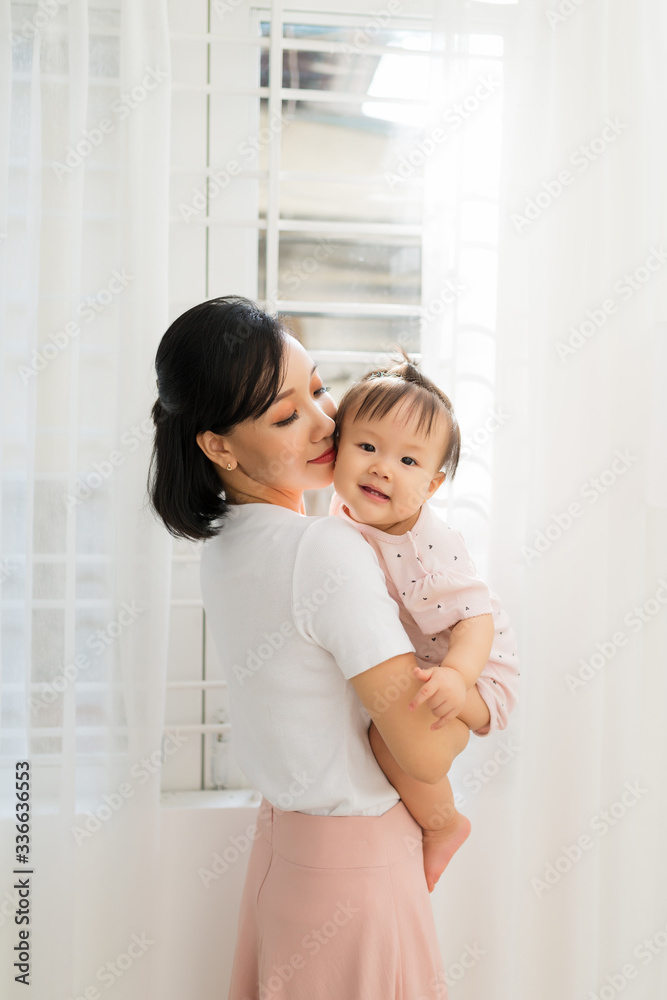 Portrait of happy vietnamese mother hugging with her cute little daughter at home Portrait of happy vietnamese mother hugging with her cute little daughter at home