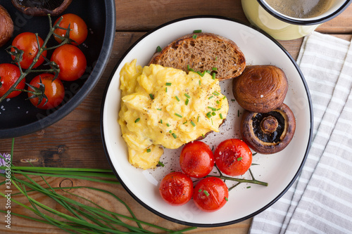 scramble egg with grilled tomatoes and mushrooms. breakfast.