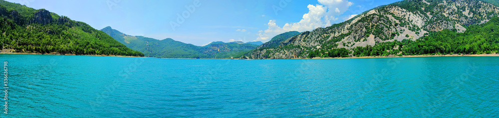 One of the main attractions of Turkey Green Canyon. Natural beauty of Turkey. Summer landscape with mountains and forest, turquoise lake. Beautiful mountain lake between rocks. Horizontal image. One of the main attractions of Turkey Green Canyon. Natural beauty of Turkey. Summer landscape with mountains and forest, turquoise lake. Beautiful mountain lake between rocks. Horizontal image.
