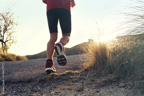 Running. man in sports outfit runs along the mountain trail.