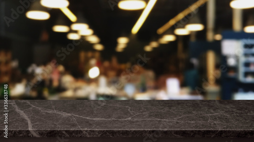 Empty black marble stone table top and blurred bokeh cafe and restaurent interior background with vintage filter - can used for display or montage your products.