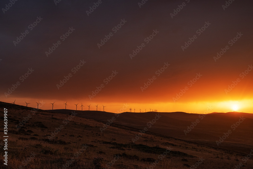 Windmills  at the the top of a mountain in a stunning sunset