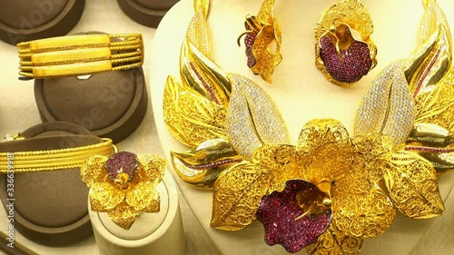 Beautiful gold necklace, earrings and rings with precious stones on display stands