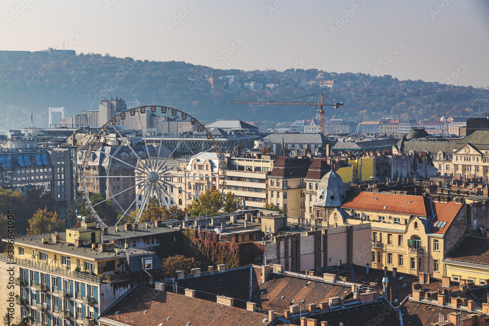 Ferris wheel and old buildings rooftop view in Budapest city center