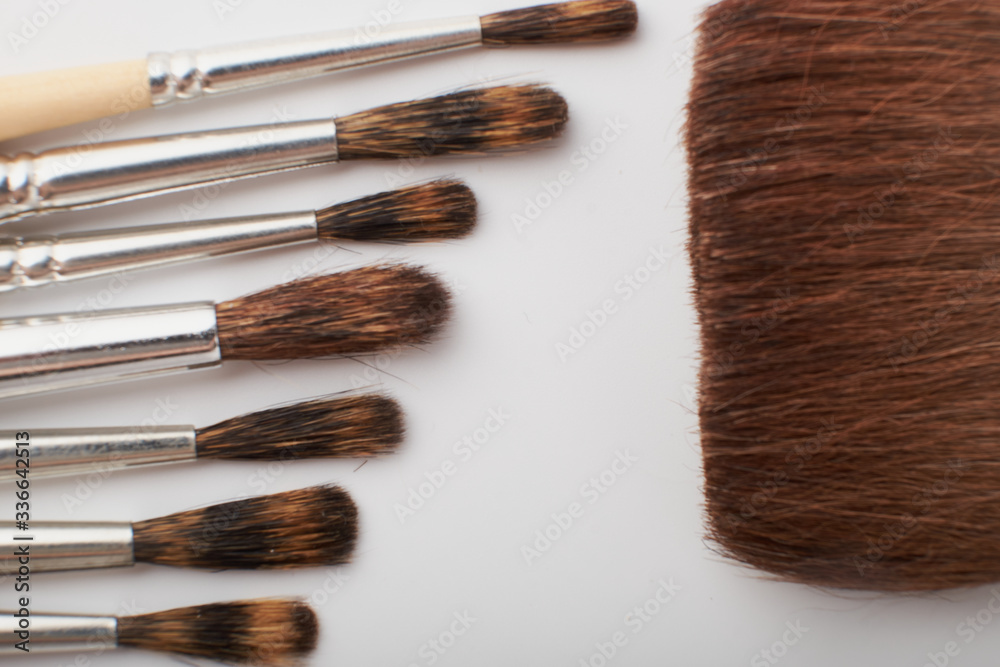 Drawing tools, set of dirty paint brushes in row on white isolated background, copy space, top view Drawing tools, set of dirty paint brushes in row on white isolated background, copy space, top view
