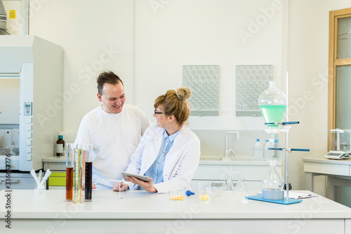 Two scientist working with tablet in CBD hemp laboratory