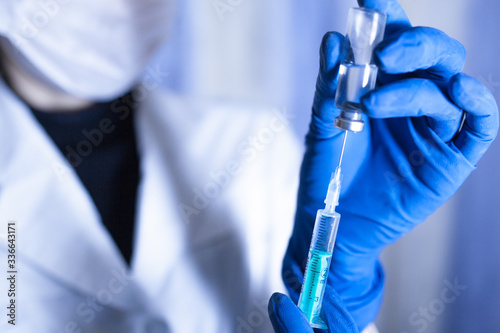 The covid-19 pandemic is concept. Syringe and hand closeup. The concept of vaccination, filling the drug into the syringe