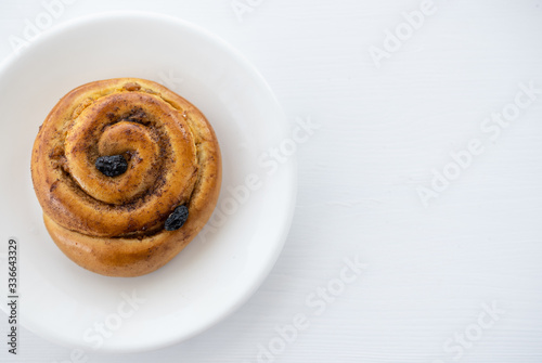 Round cinnamon roll on a white plate