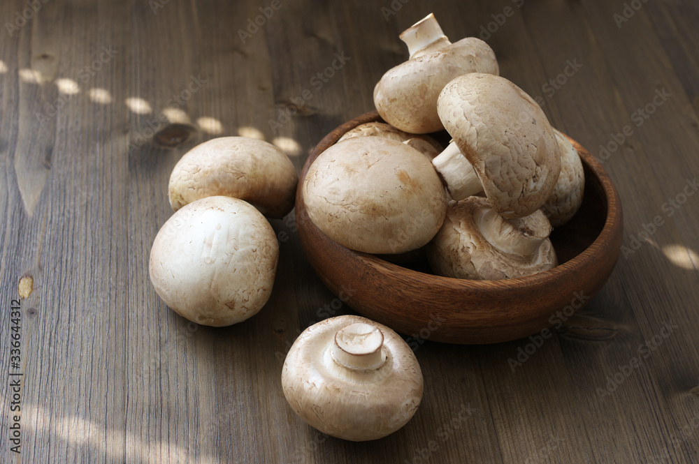 Champignon mushrooms in wood bowl Champignon mushrooms in wood bowl