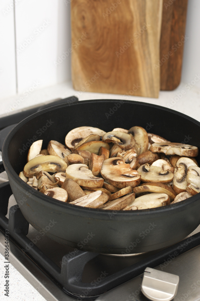 Chopped champignon mushrooms frying in pan Chopped champignon mushrooms frying in pan
