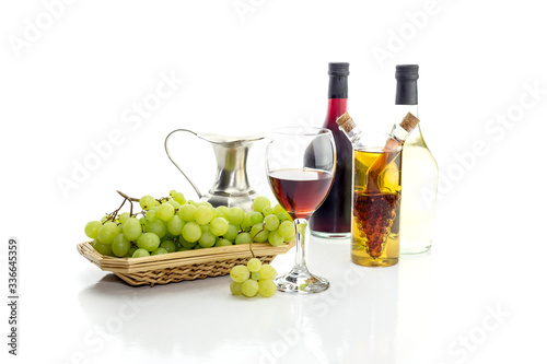 Bottles of wine  pitcher  wine glass and grapes on a white background close-up