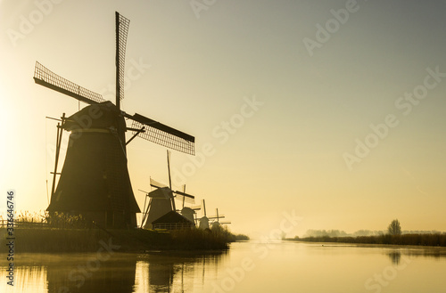 Low angle view of a row of wind mills in early morning sunlight at Kinderdijk, the Netherlands