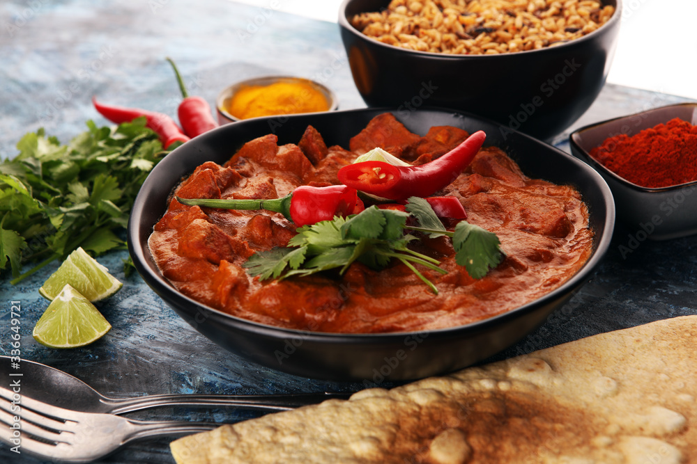 Chicken tikka masala spicy curry meat food in pot with rice and naan bread. indian food on table