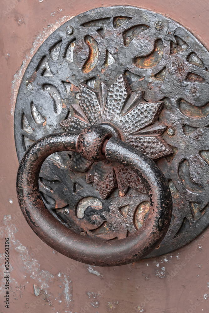 Door knocker. Ancient architecture. Iron fittings on the gate. Entrance to the house. Retro style. Historical building. Antique church. Closed entrance. The decor of the exterior. Door knocker. Ancient architecture. Iron fittings on the gate. Entrance to the house. Retro style. Historical building. Antique church. Closed entrance. The decor of the exterior.