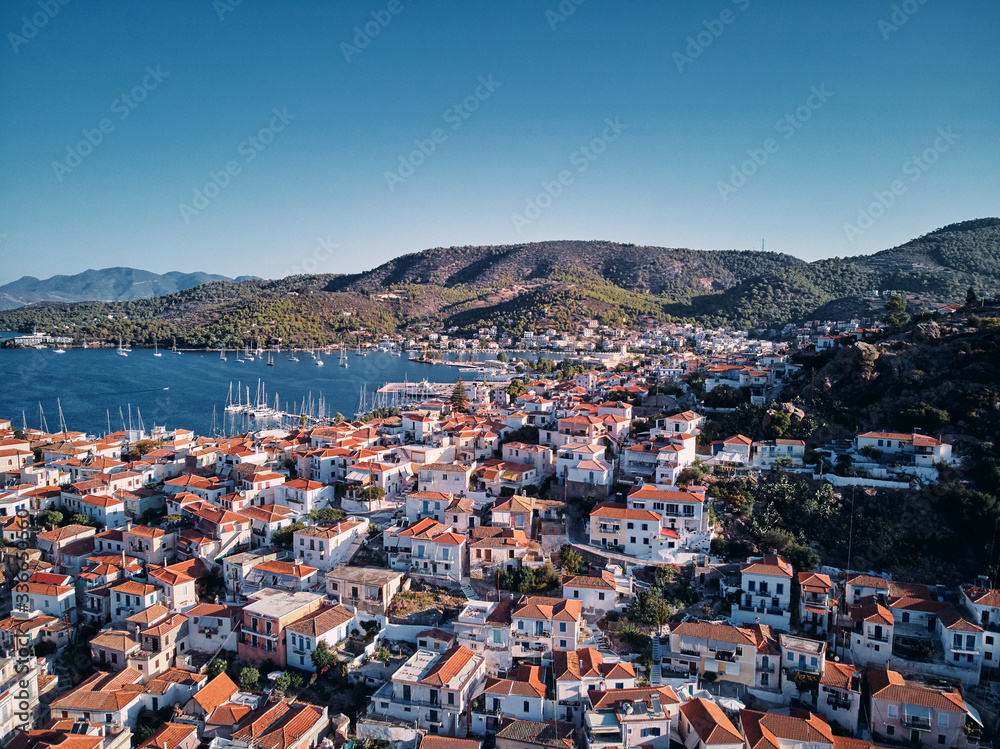 Scenic view of Poros island in a typical summer day. Old town with traditional white houses near the sea. Saronic gulf, Greece, Europe.