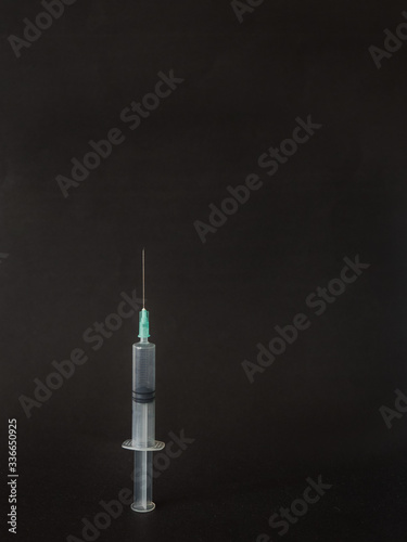 Syringe on black background with copy space