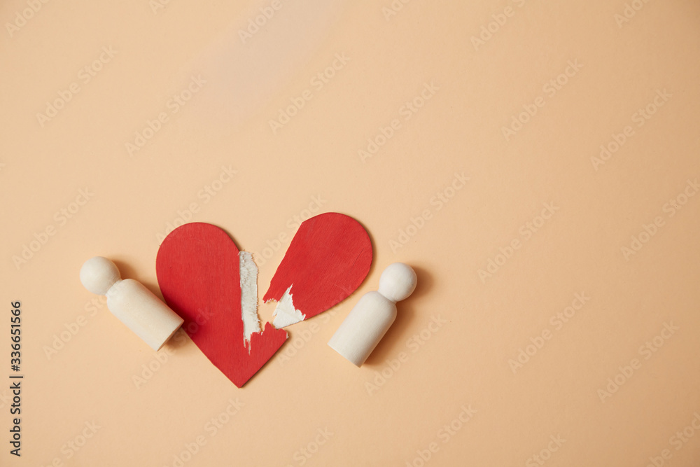 Relationship breakdown mockup. Broken heart. End of love. Divorce and separation. Red heart and wooden people figures Relationship breakdown mockup. Broken heart. End of love. Divorce and separation. Red heart and wooden people figures
