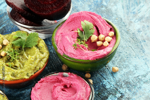 A variety of colored hummus, beetroot hummus, hummus with avocado on background. Veggie Clean eating, dieting, vegetarian party food.