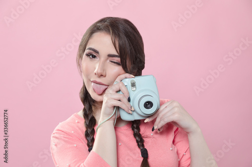 Woman holding up camera and wiking photo