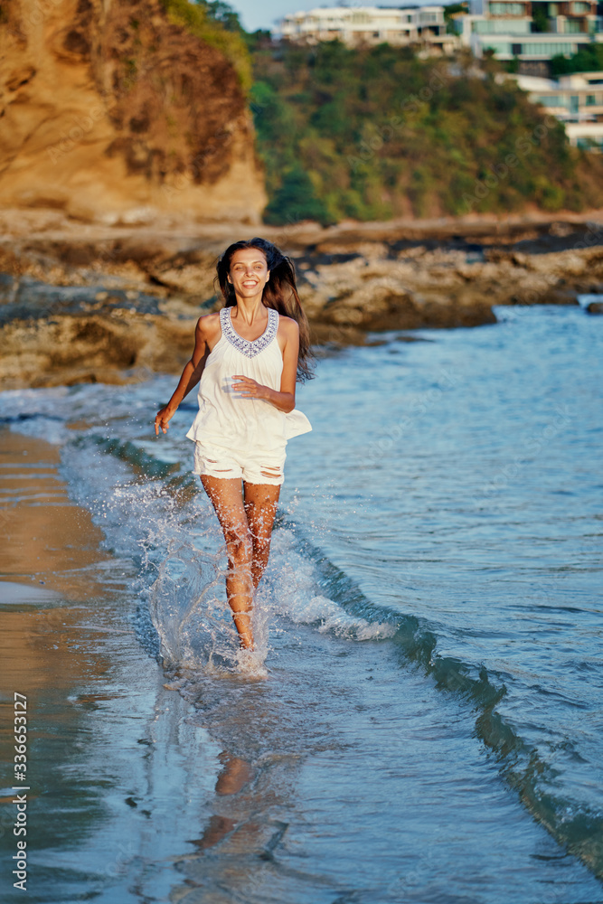 Outdoor portrait of young beautiful woman with long hair walking on the sea beach. Outdoor portrait of young beautiful woman with long hair walking on the sea beach.