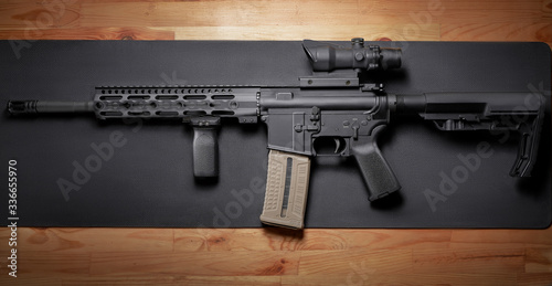 Fotografija AR-15 rifle on wooden table.