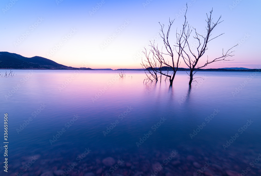 The last sunrays over a blue water mirror. Lake.