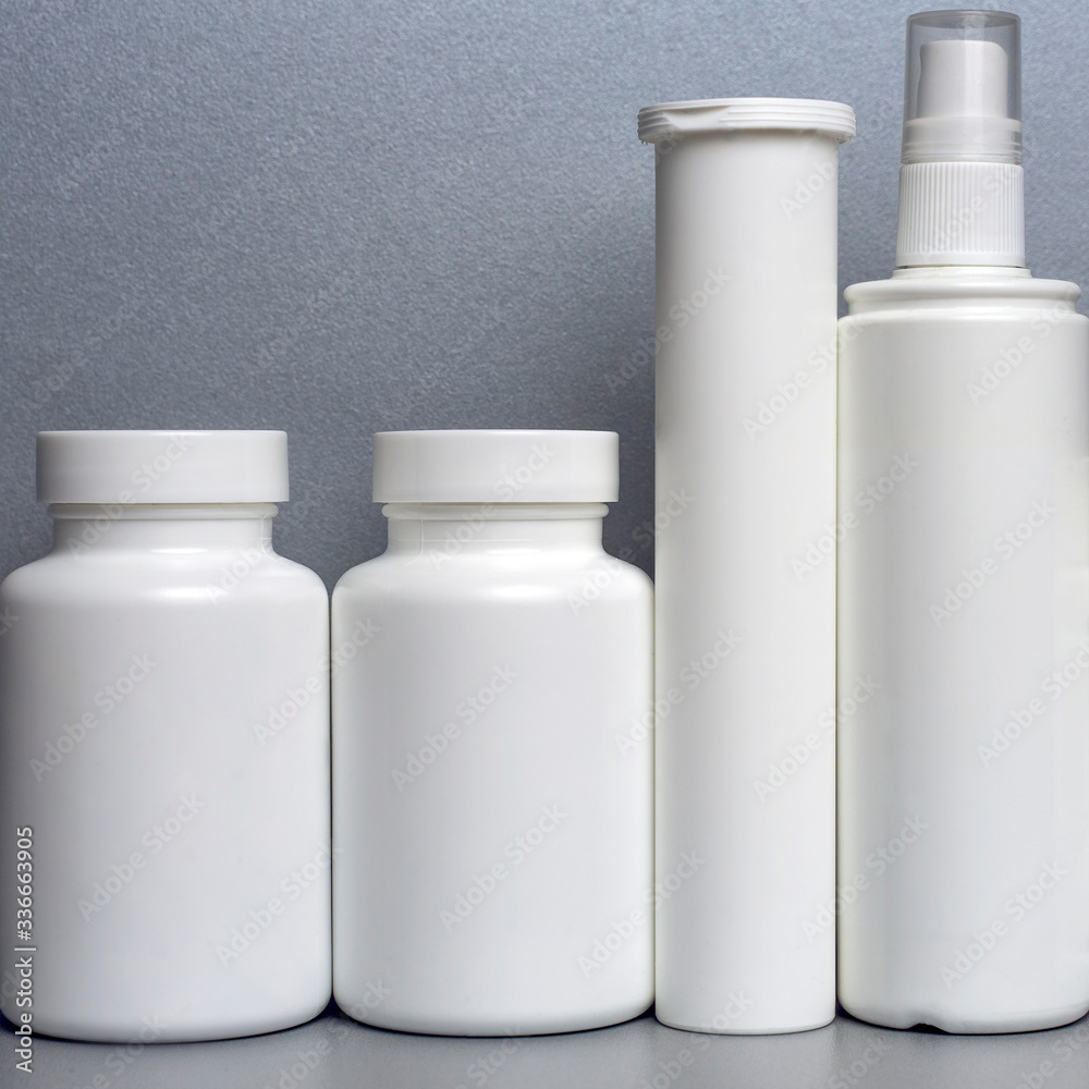 photo of four plastic cans for package pills and vitamins and antiseptic spray for protection against coronavirus KOVID-19 on a gray background. Suita for articles. photo without bottle labels photo of four plastic cans for package pills and vitamins and antiseptic spray for protection against coronavirus KOVID-19 on a gray background. Suita for articles. photo without bottle labels
