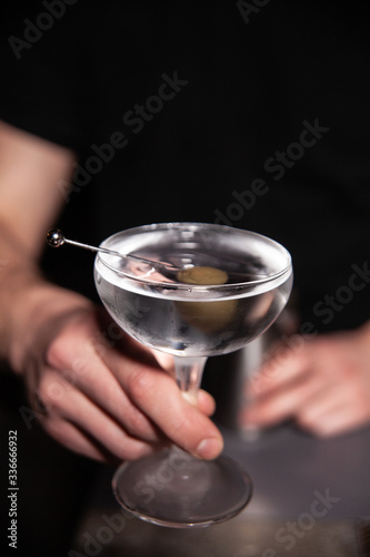 bartender holds a glass with a drink