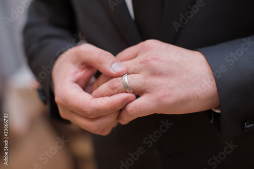 The man wears a ring on his hand . She is wearing a ring in her house