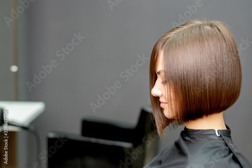 Woman with short hairstyle in hair salon with copy space. Toned.