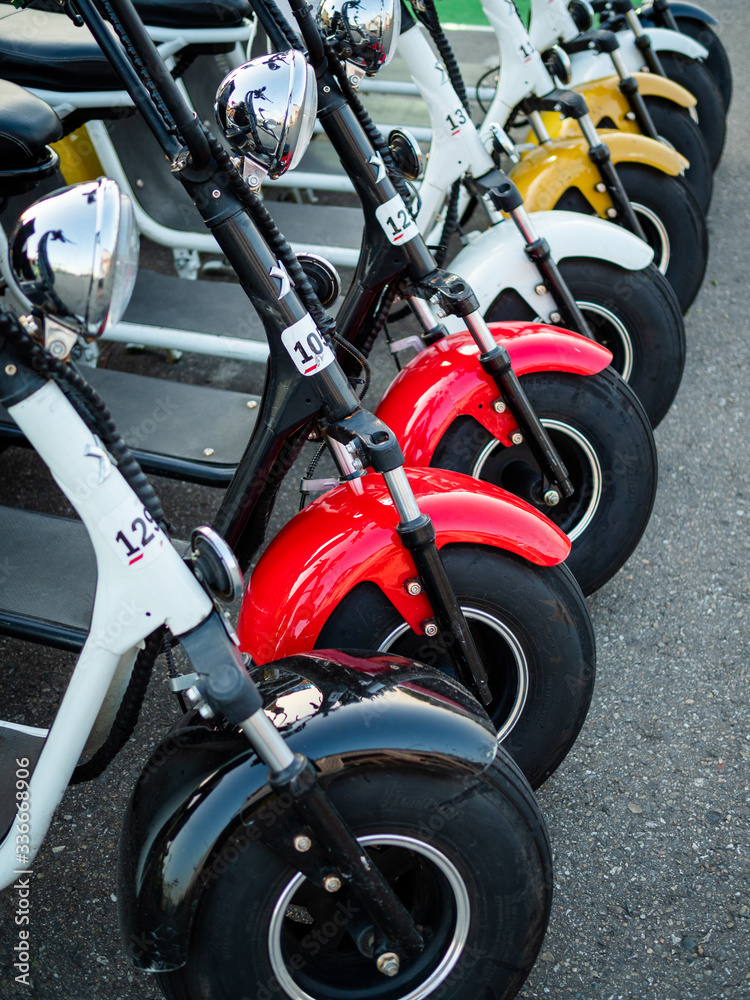 Motor vehicle rental station. Motorbikes, moped, scooters of different colors are standing in a
