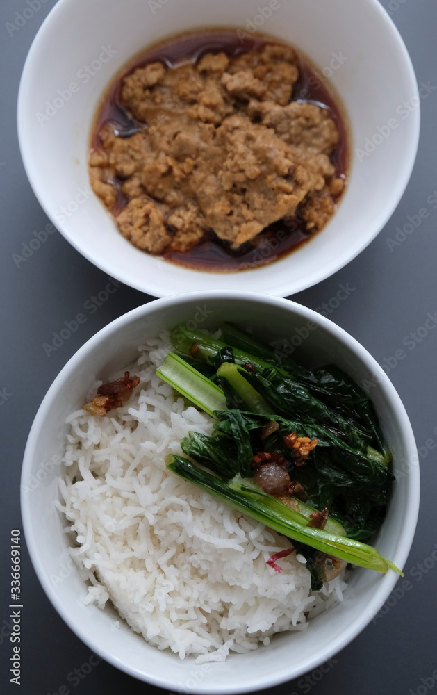 Simple Chinese Home Cooked Lunch Top View. Purposely focus on the rice bowl. Simple Chinese Home Cooked Lunch Top View. Purposely focus on the rice bowl.