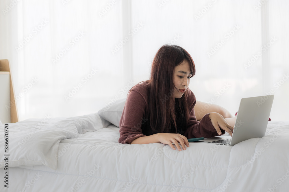 Asian woman using laptop for working, educational, e-commerce, social media in her bed. corovavirus covid-19, stay at home, work form home concept. Asian woman using laptop for working, educational, e-commerce, social media in her bed. corovavirus covid-19, stay at home, work form home concept.