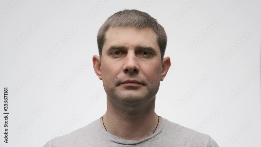 Young man takes off medical mask. Breathes deeply and smiling looking at camera. White background. Health care and medical concept. Stop pandemia. Close up portrait . 4k Young man takes off medical mask. Breathes deeply and smiling looking at camera. White background. Health care and medical concept. Stop pandemia. Close up portrait . 4k