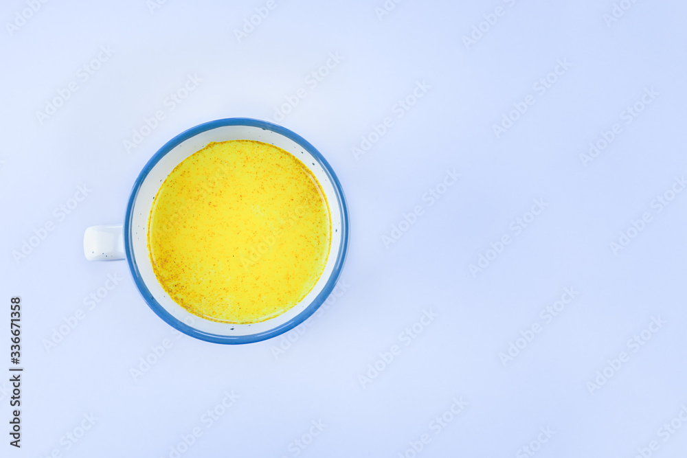 Golden milk in a Cup on a gray table with a copy space. Alternative medicine concept. Golden milk in a Cup on a gray table with a copy space. Alternative medicine concept.
