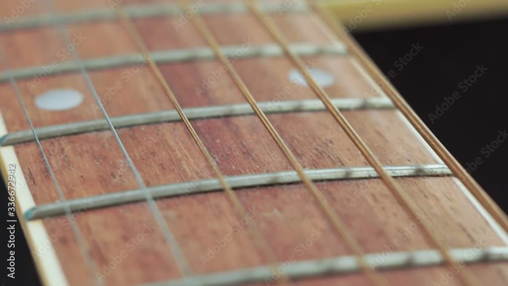 guitar strings and frets for making music. Selective focus on one guitar threshold.