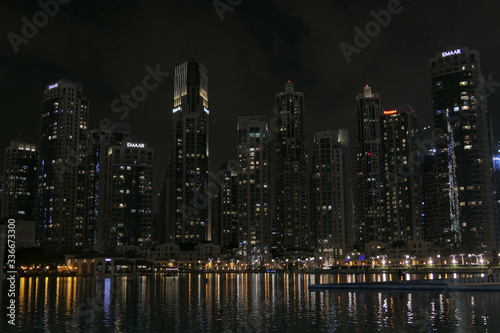 Dubai skyscrappers in the night. Reflection from the river.