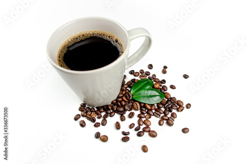 Cup of coffee with beans and green coffee leafs