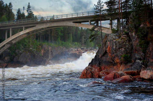  High concrete bridge over a stormy mountain river