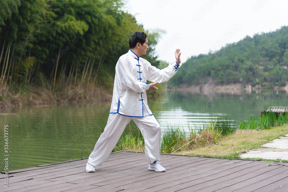An Asian elderly man doing sports by the lake