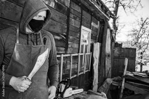 Brutal man in a mask with a knife in the hood