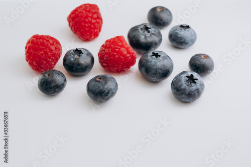 juicy fresh berries blueberries and raspberries are on the white table