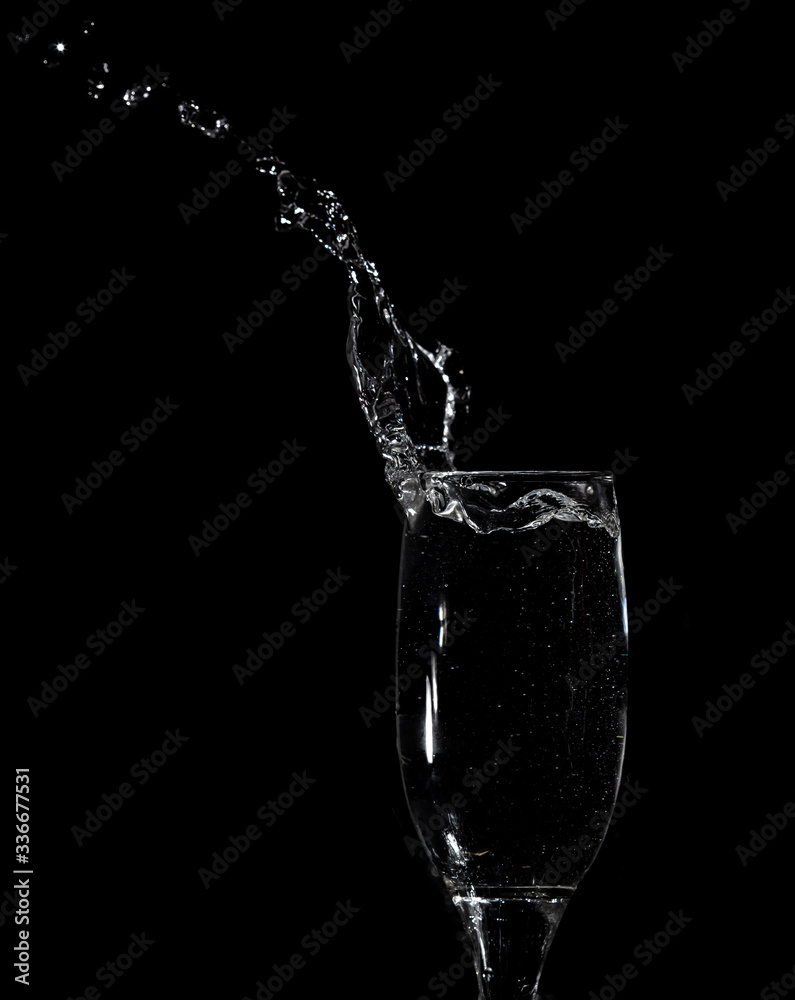 Splashes and drops of water in a glass are isolated on a black . Splashes and drops of water in a glass are isolated on a black .