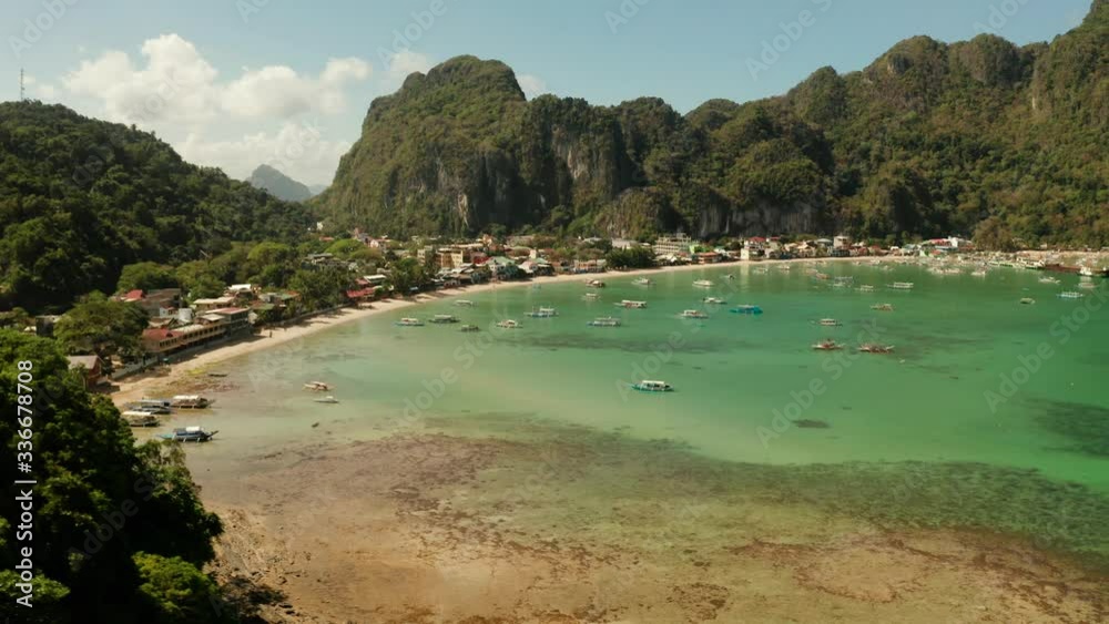 Town of El Nido in the bay with the blue lagoon and tourist boats. Aerial view. Famous tourist place on the island of Palawan. Seascape with blue bay and boats view from above. Summer and travel Town of El Nido in the bay with the blue lagoon and tourist boats. Aerial view. Famous tourist place on the island of Palawan. Seascape with blue bay and boats view from above. Summer and travel