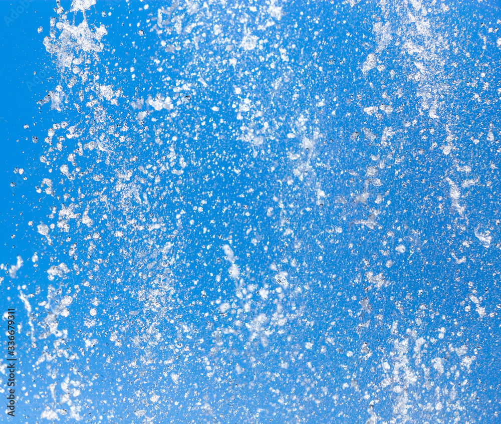 Splashing water from a fountain on a background of blue sky